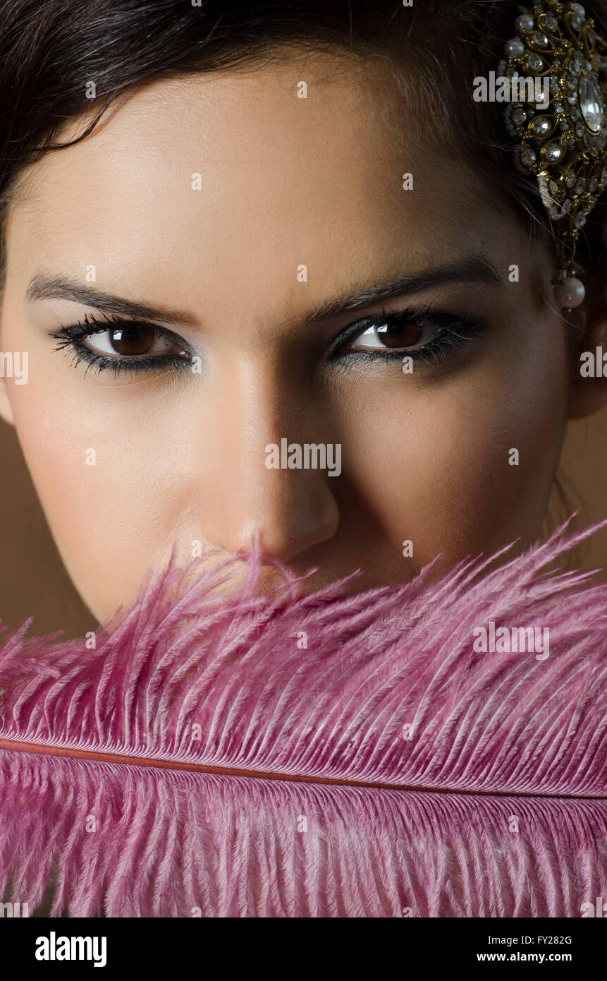 Beautiful Asian woman hiding face with a feather Stock Photo