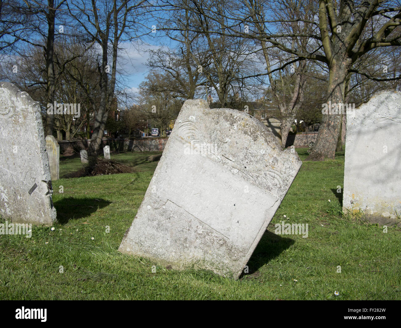 Heavenly hazard - a leaning grave stone in a churchyard in Sudbury, Suffolk. Stock Photo