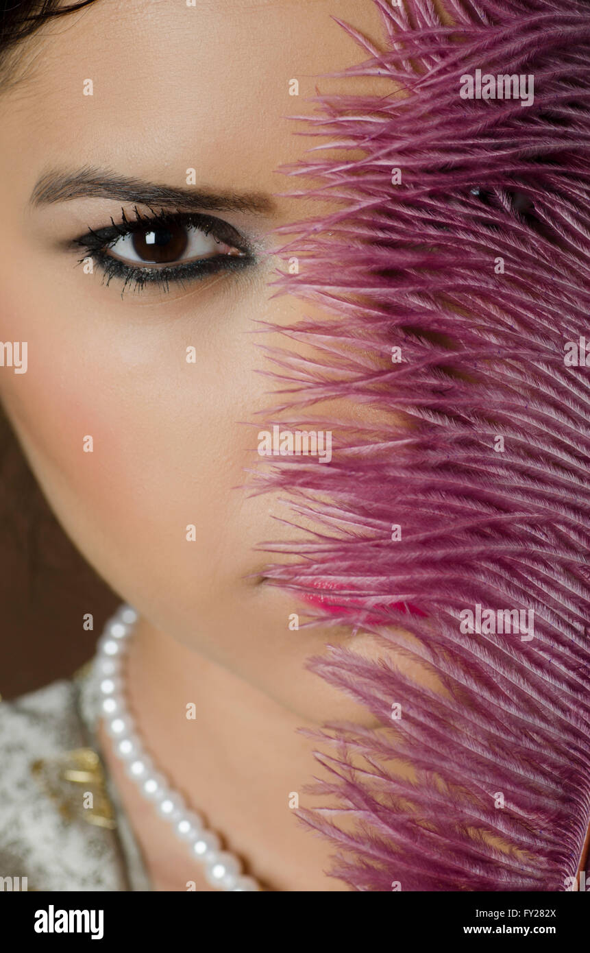 Beautiful Asian woman hiding face with a feather Stock Photo