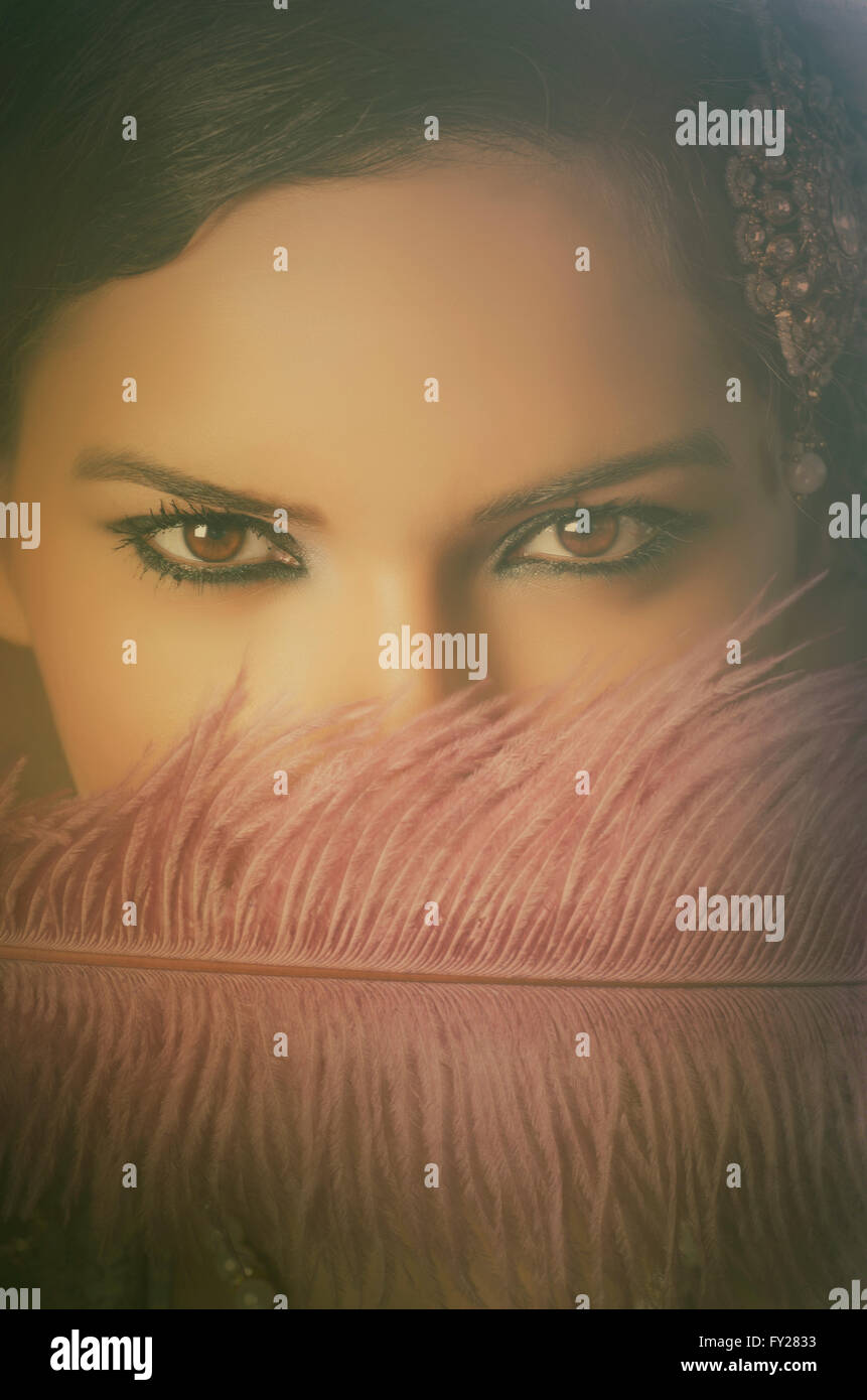 Beautiful Asian woman hiding face with a feather Stock Photo
