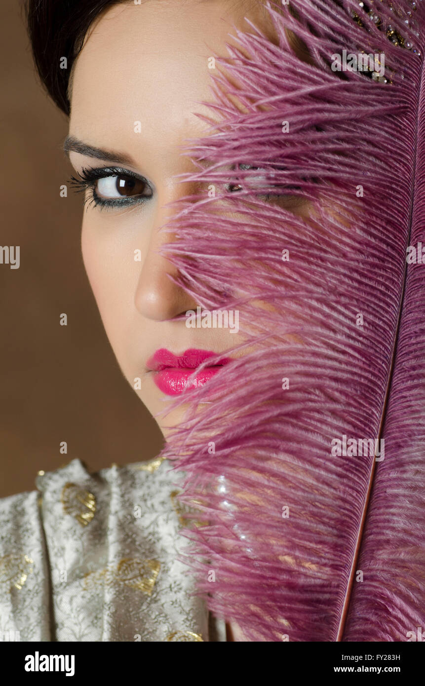 Beautiful Asian woman hiding face with a feather Stock Photo