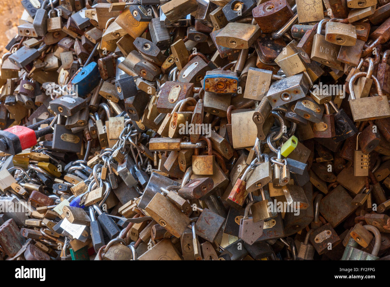 Many love padlocks locked on iron chain at landmark, tourists place. City Pecs of Hungary Stock Photo