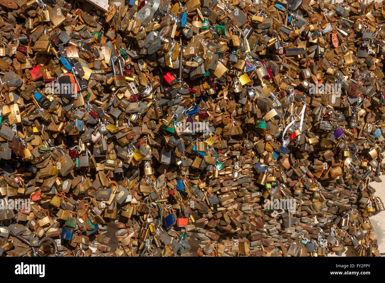 Many love padlocks locked on iron chain at landmark, tourists place. City Pecs of Hungary Stock Photo