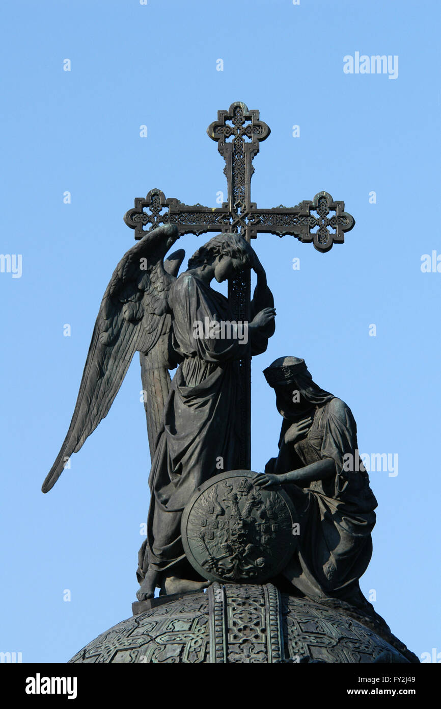 Statue of an angel holding a cross and a knelling woman represented Russia topped the Monument to the Millennium of Russia (1862) designed by Russian sculptor Mikhail Mikeshin in Veliky Novgorod, Russia. Stock Photo