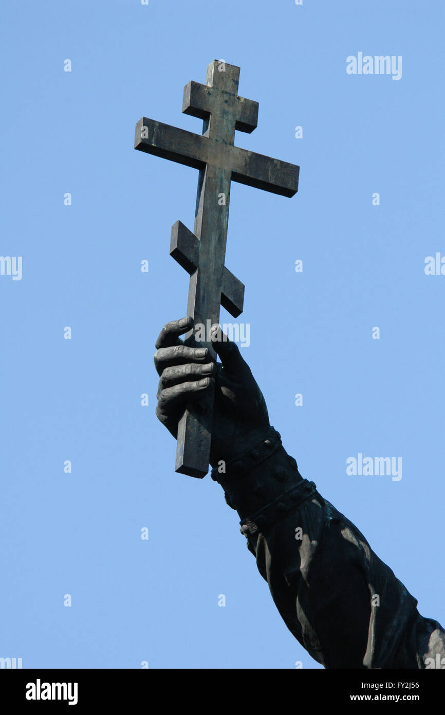 Hand raising an Orthodox cross. Detail of the Monument to the Millennium of Russia (1862) designed by Russian sculptor Mikhail Mikeshin in Veliky Novgorod, Russia. The hand is a part of the statue of Grand Prince Vladimir the Great representing the Christianization of Kievan Rus (988). Stock Photo