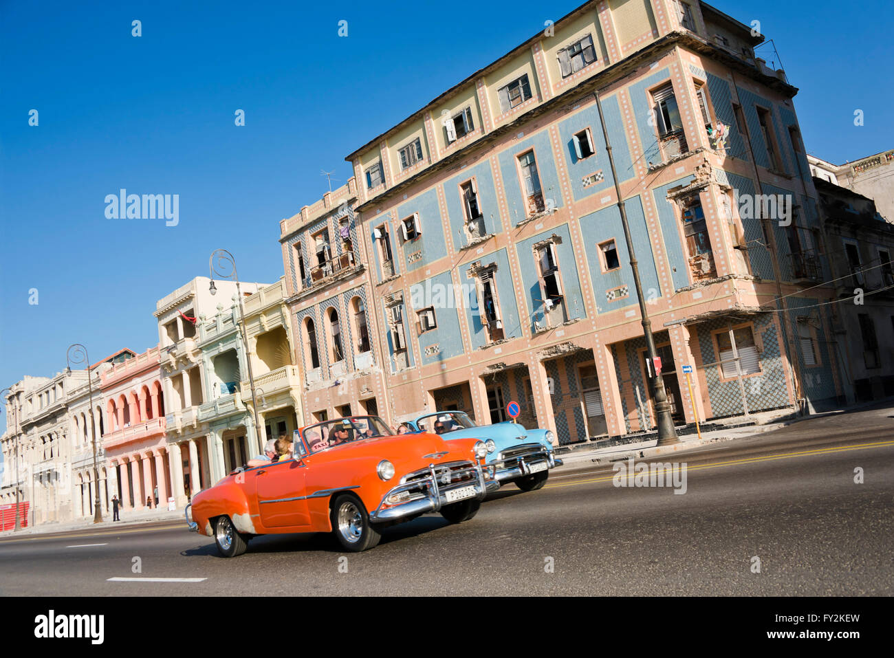 Horizontal view of classic American cars driving down the Malecon in Havana, Cuba. Stock Photo