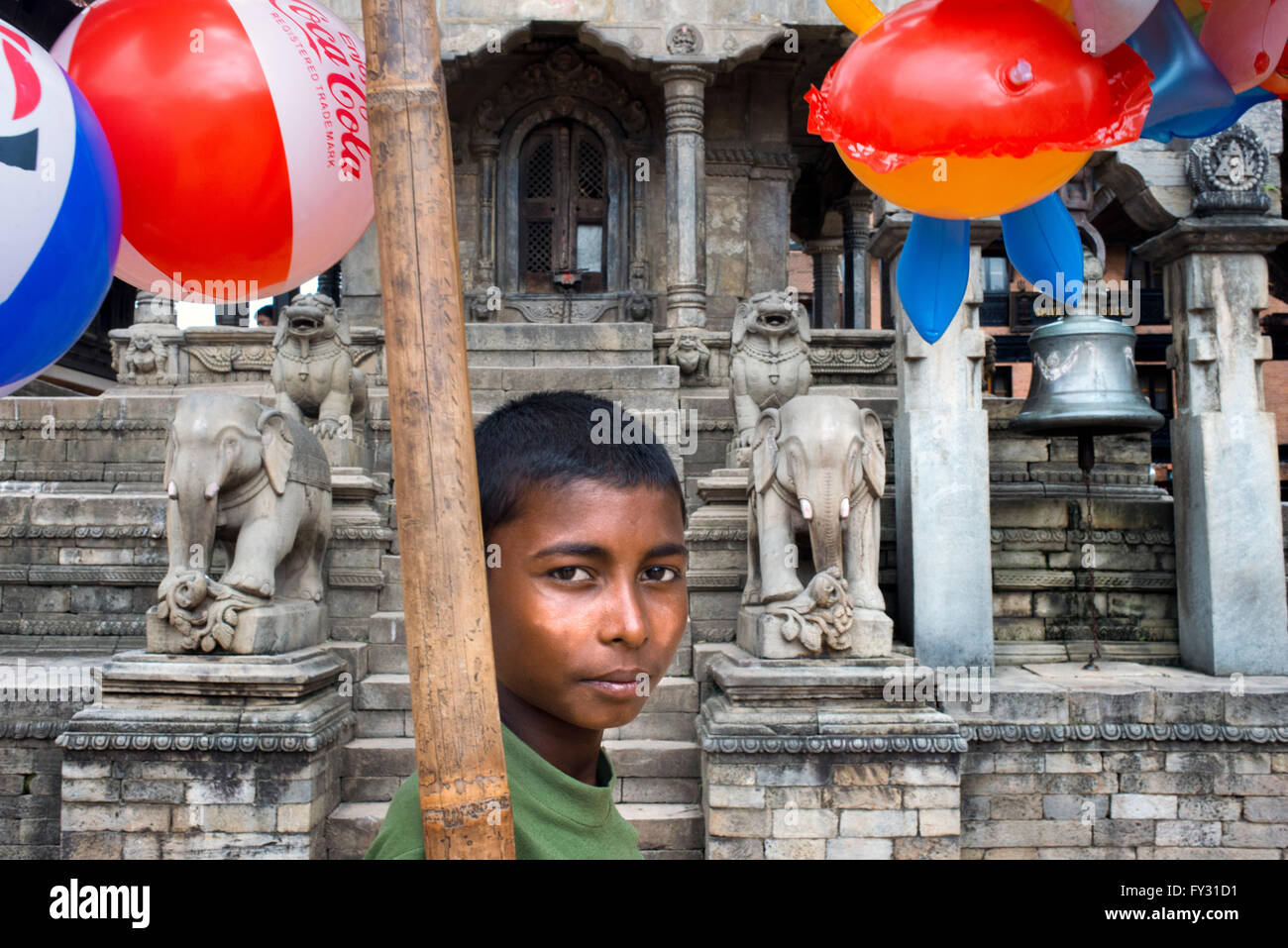 Local child selling balloms at Vatsala Durga Temple, Durbar Square, Bhaktapur, Nepal Stock Photo