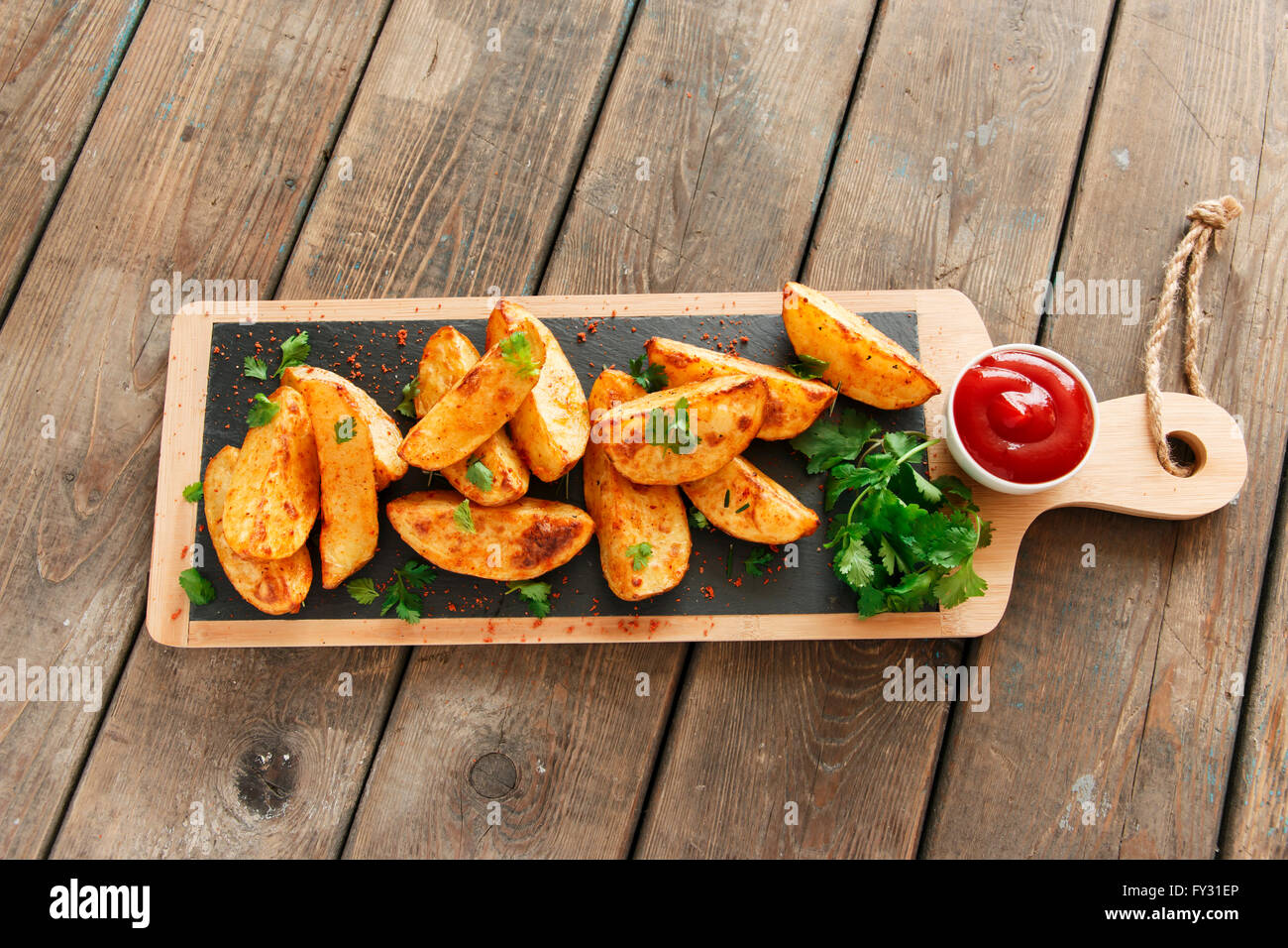 baked roasted potato wedges with herbs Stock Photo