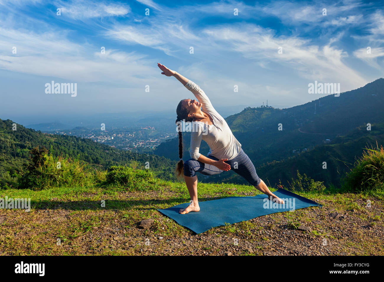 Woman practices yoga asana Utthita Parsvakonasana outdoors Stock Photo