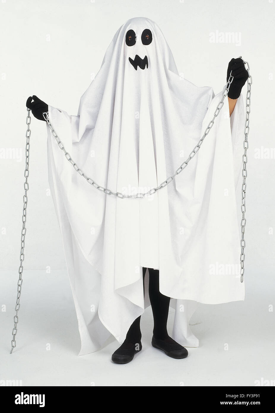 Figure dressed in white sheet and holding a chain, to look like a ghost Stock Photo