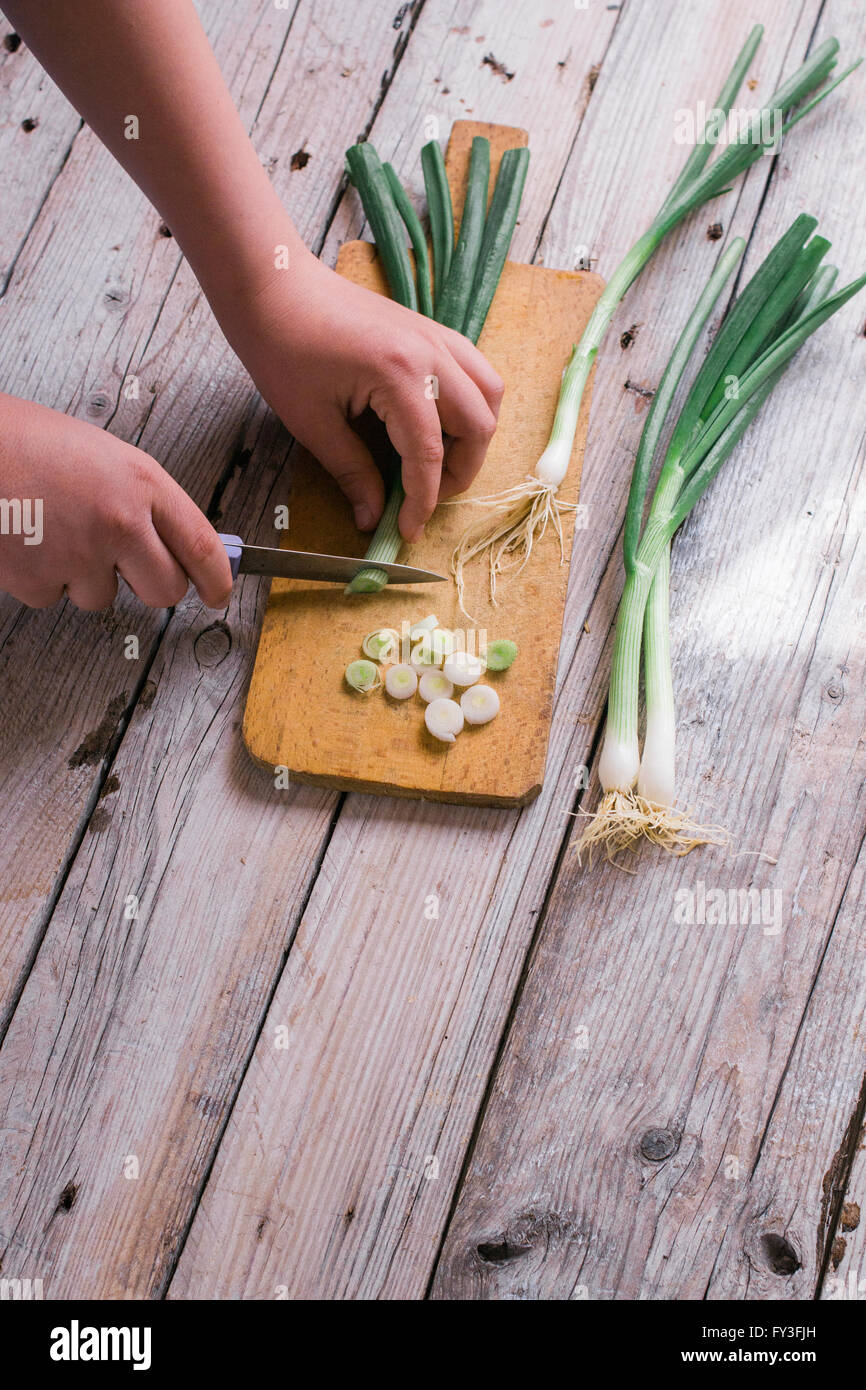 Cutting green onions on a wooden background Stock Photo - Alamy