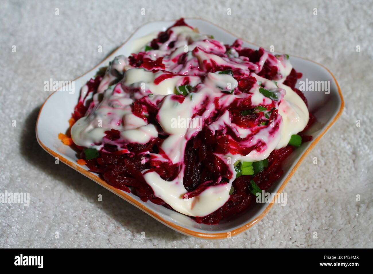 appetizing fresh vegetarian salad from young beet under sauce in plate Stock Photo