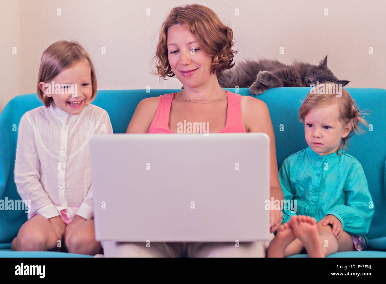 Mother with little daughters watching the laptop. Selective focus. Stock Photo