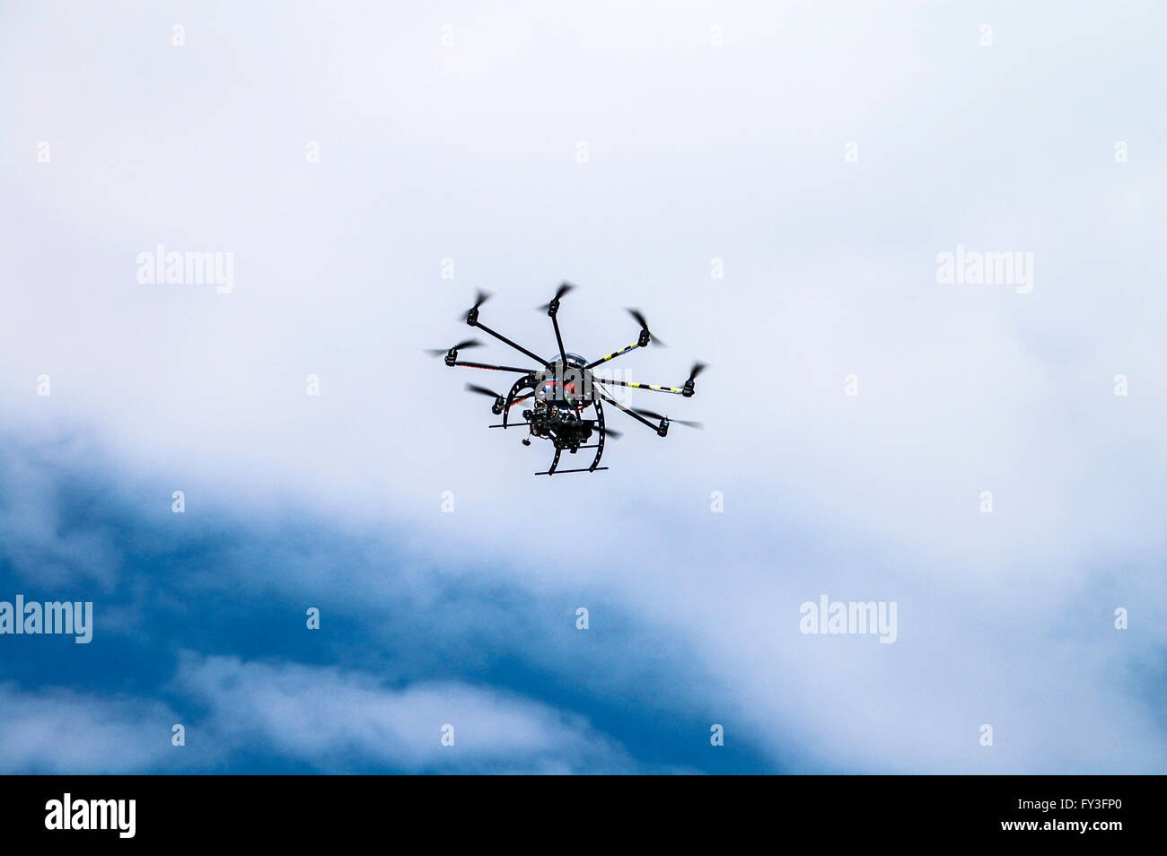 Aircraft type Dron photographed from the ground in flight and shooting events below it. Stock Photo