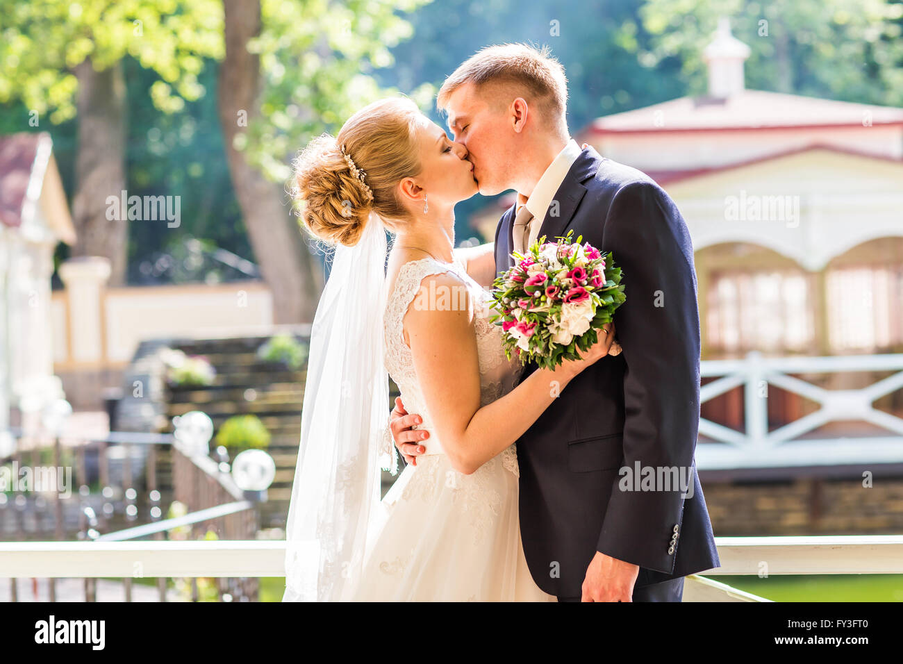 Kiss the bride and groom Stock Photo - Alamy