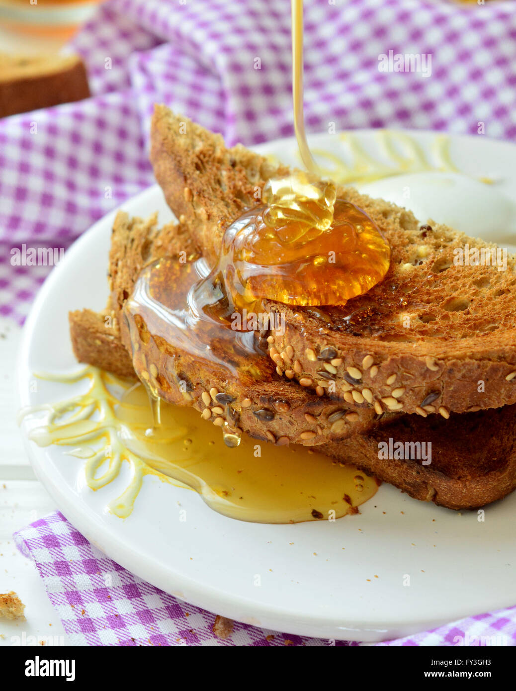 Honey poured on toast - breakfast Stock Photo