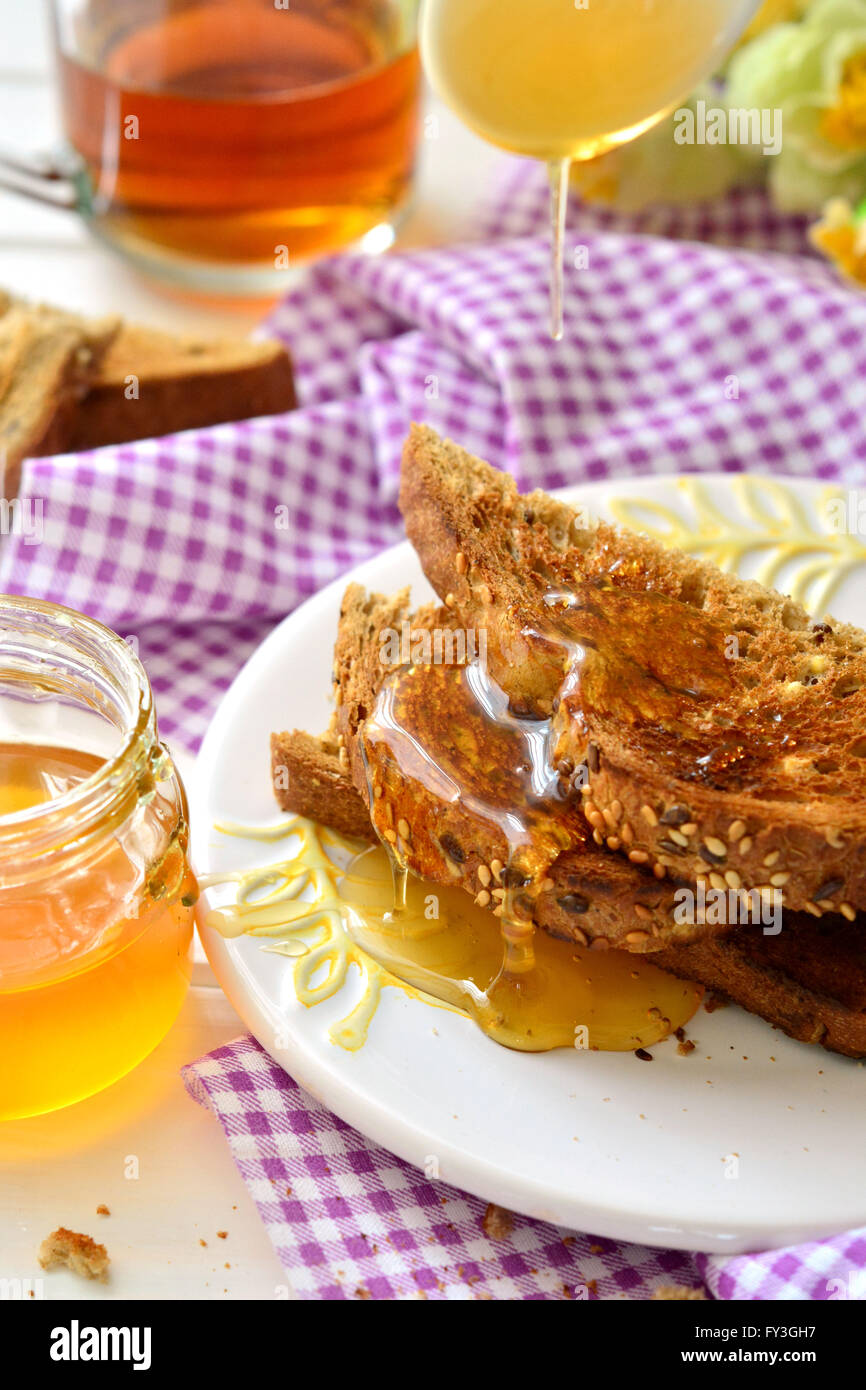 Honey poured on toast - breakfast Stock Photo