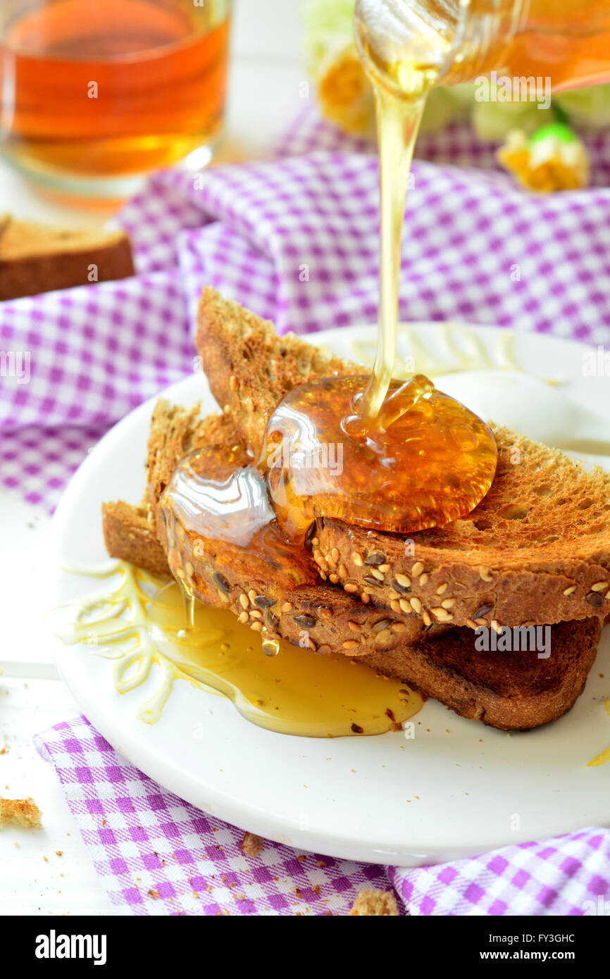Honey poured on toast - breakfast Stock Photo