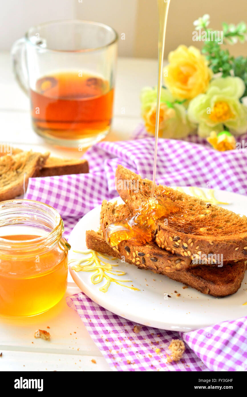 Honey poured on toast - breakfast Stock Photo