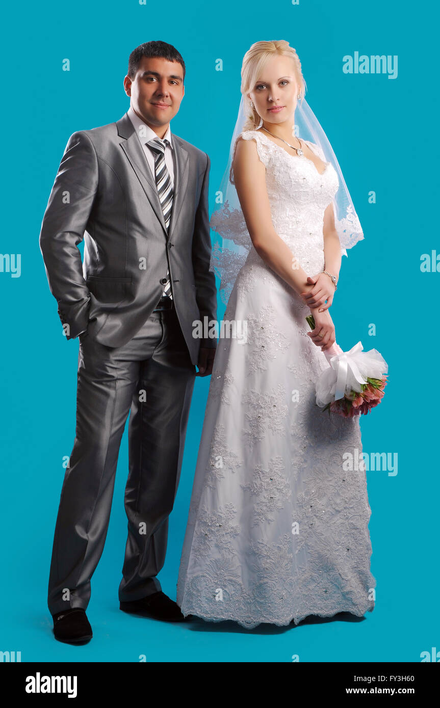 Loving newlyweds standing on a blue background Stock Photo