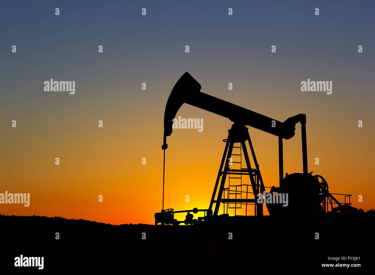 Oil pump silhouette over sunset sky Stock Photo