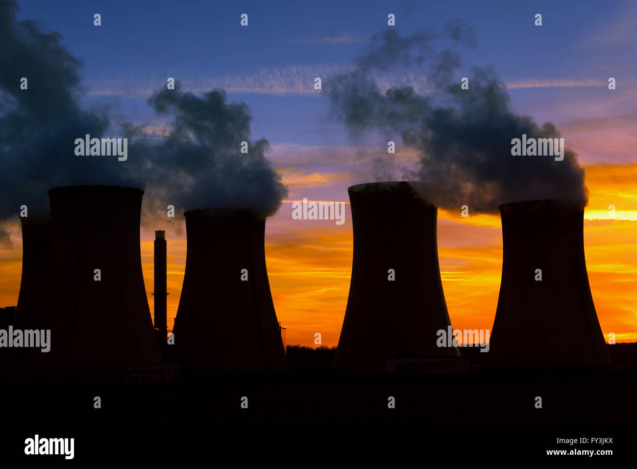 Silhouette of power plant at sunset Stock Photo
