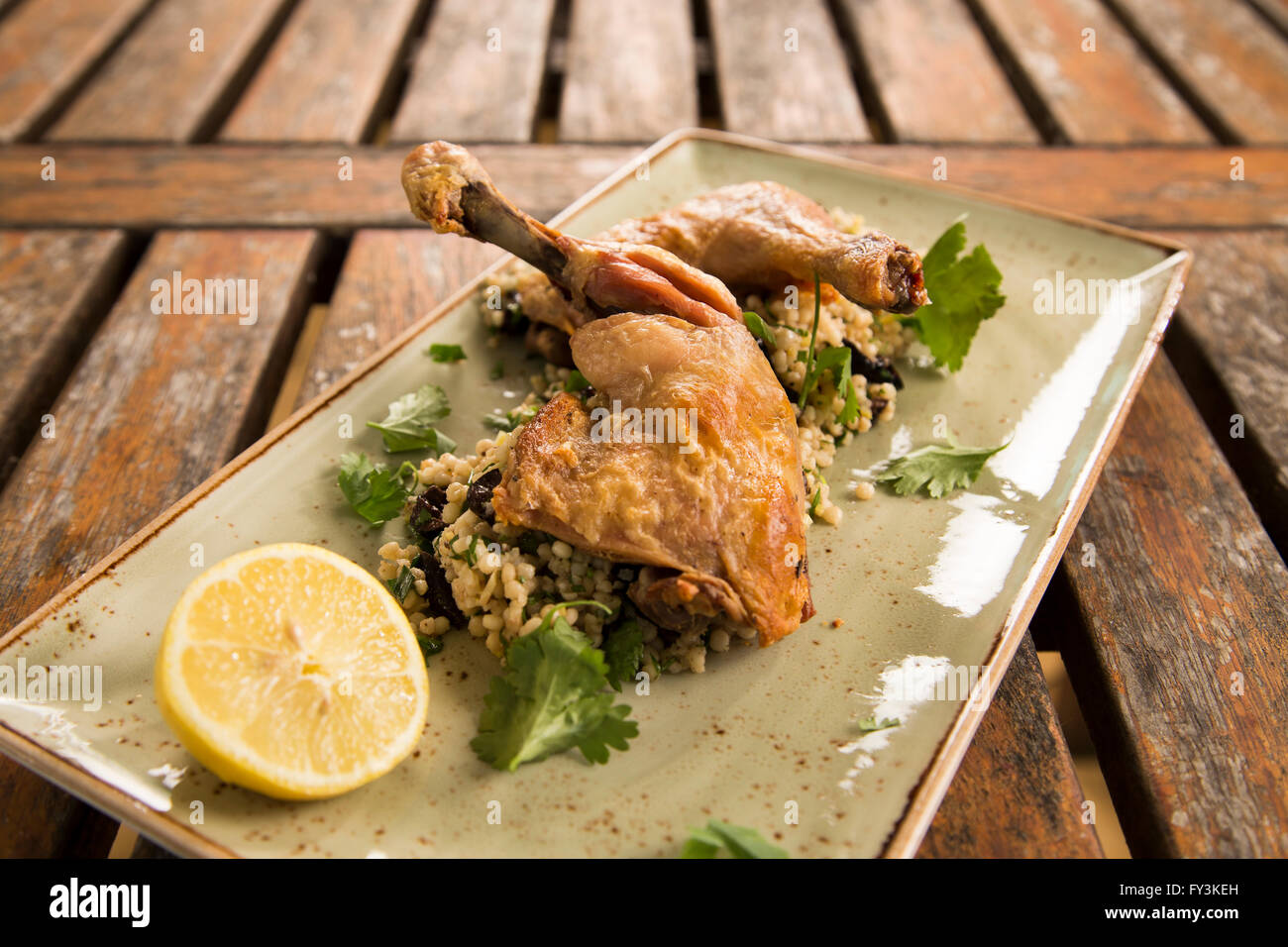 Confit chicken with lemon, olive & herb cous cous Stock Photo