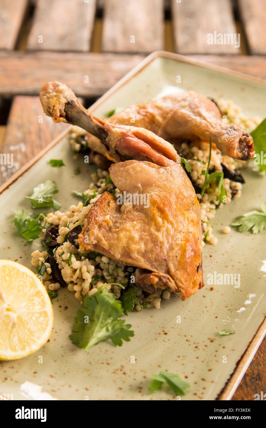 Confit chicken with lemon, olive & herb cous cous Stock Photo