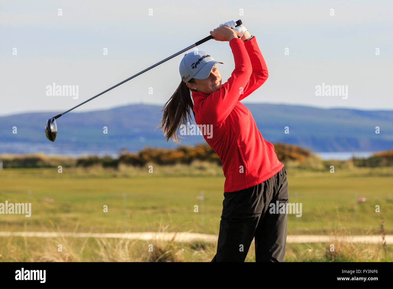 Young woman playing golf and swinging a driver, Royal Troon, Golf Club, Ayrshire, Scotland, UK Stock Photo