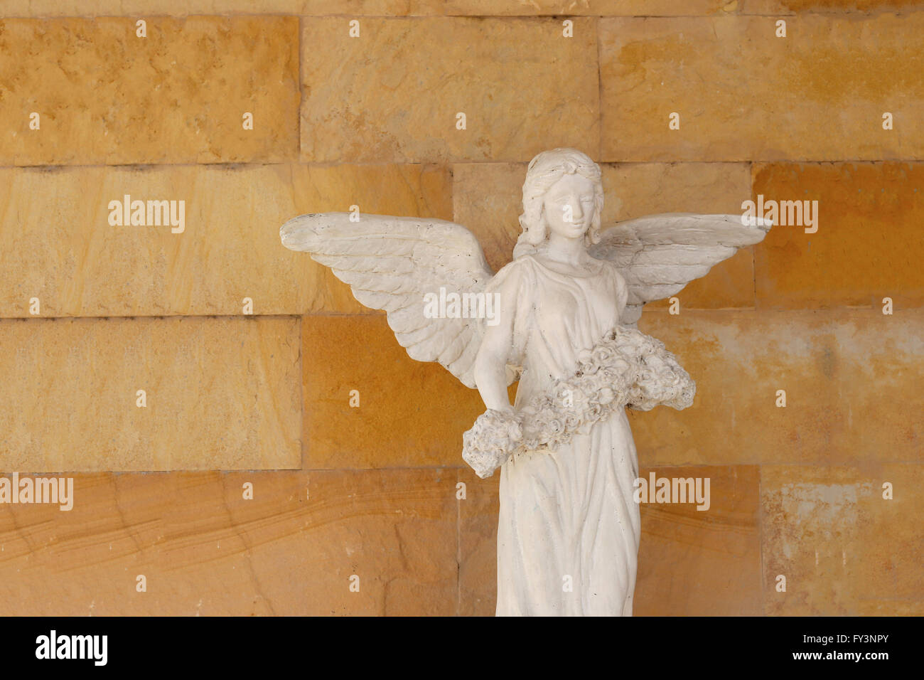 Old Angel statue with have a backdrop is brown brick wall Stock Photo