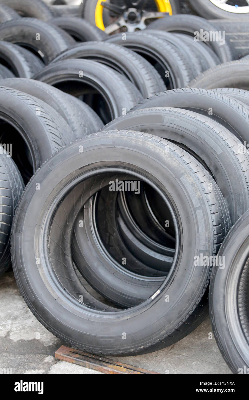 Pile of used rubber tyres in the garage shop. Stock Photo