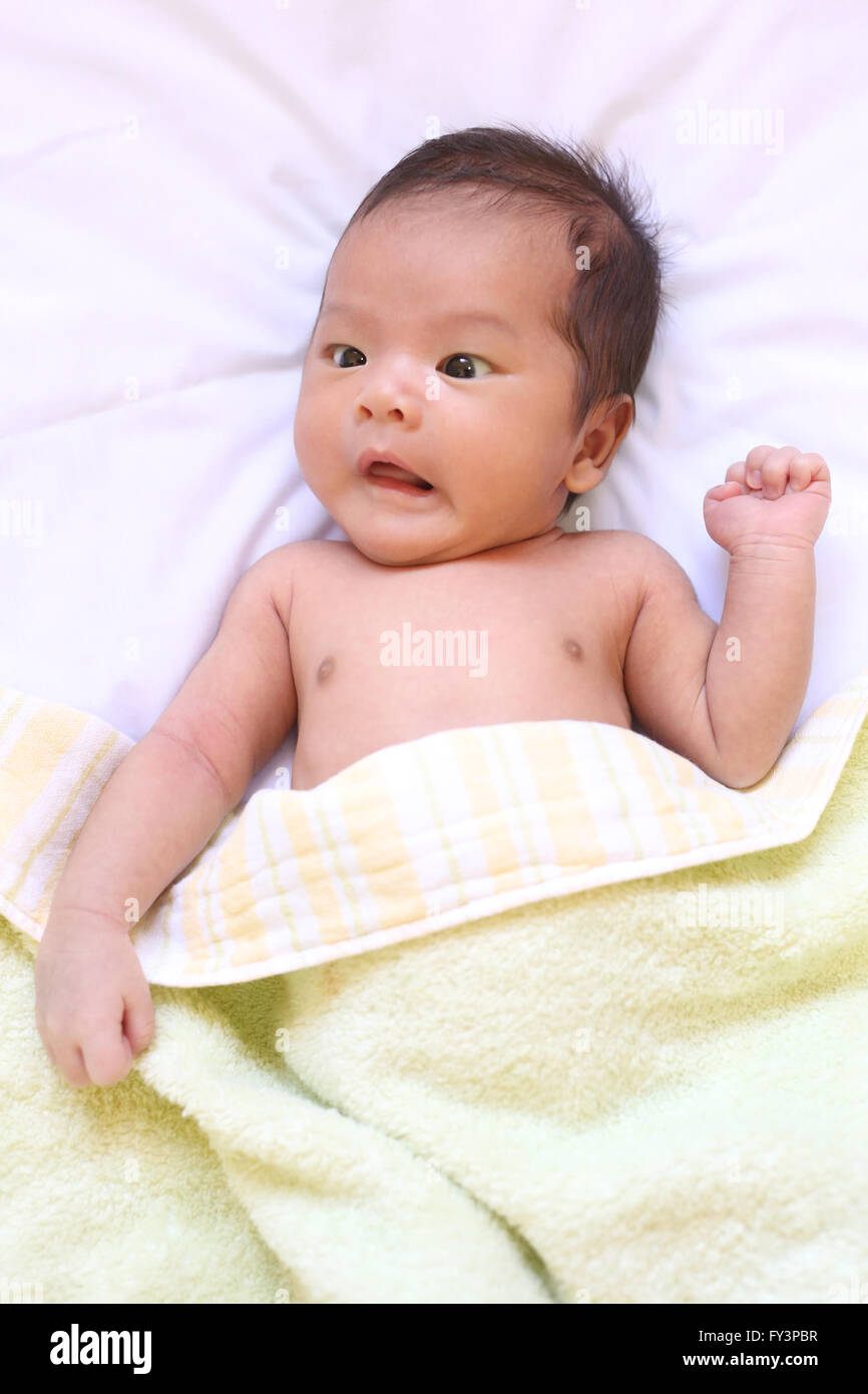 Newborn baby of asia relax in a good mood on white bed and looked amazement in express their feelings. Stock Photo