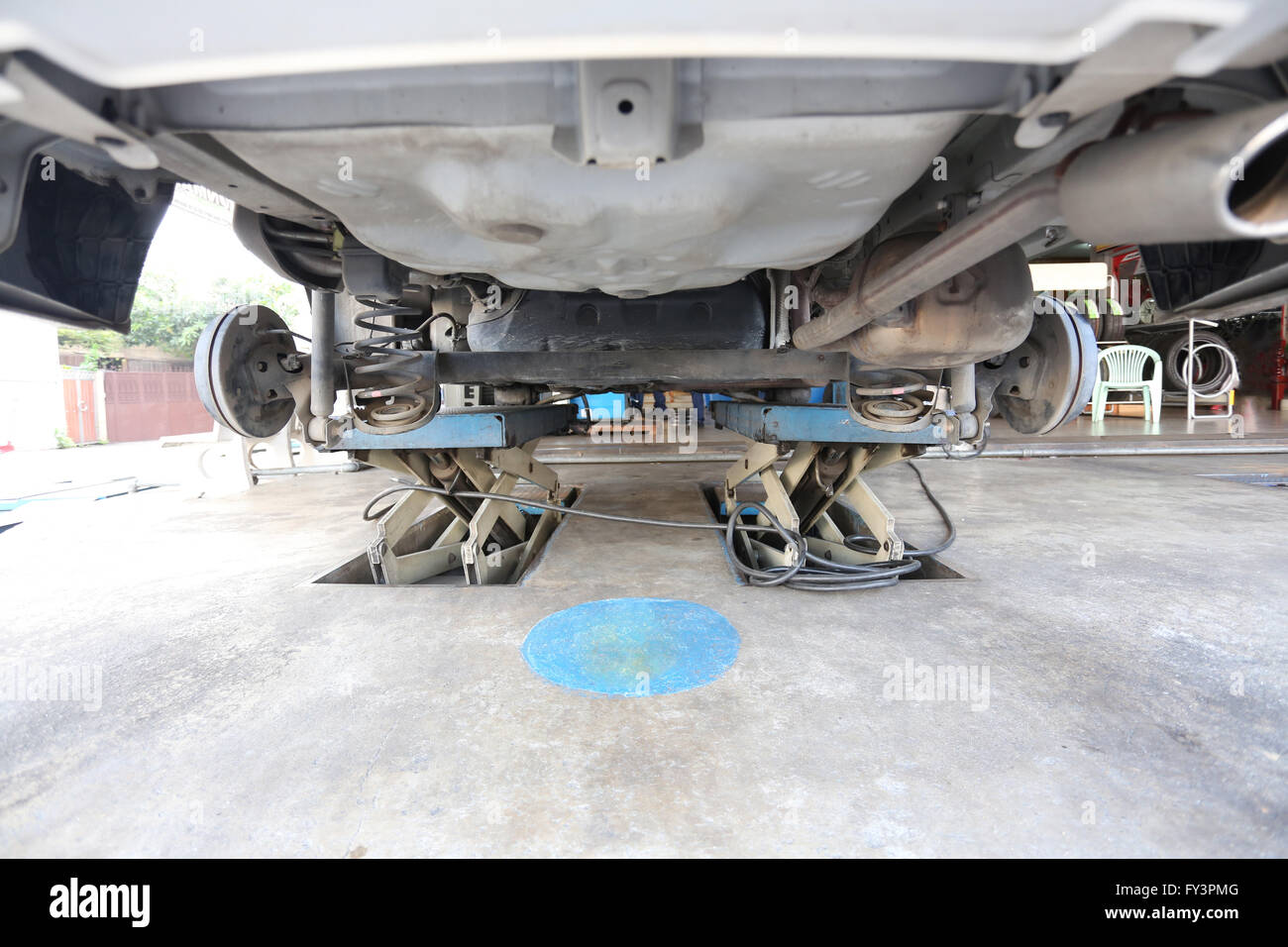 Look under the car at inspection for maintenance in garage shop. Stock Photo