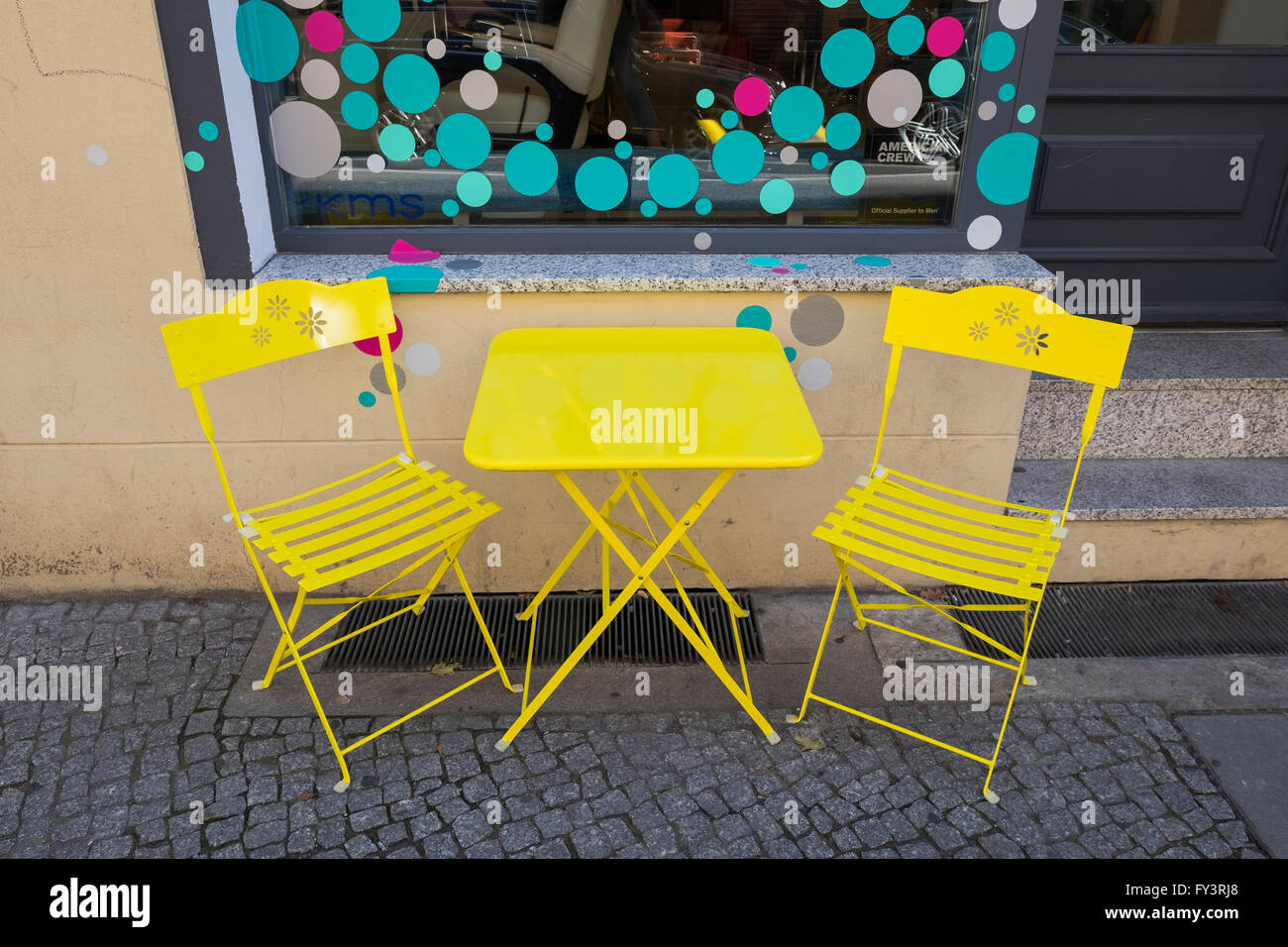 A yellow table and two yellow chairs outside a cafe in Berlin, Germany. Stock Photo