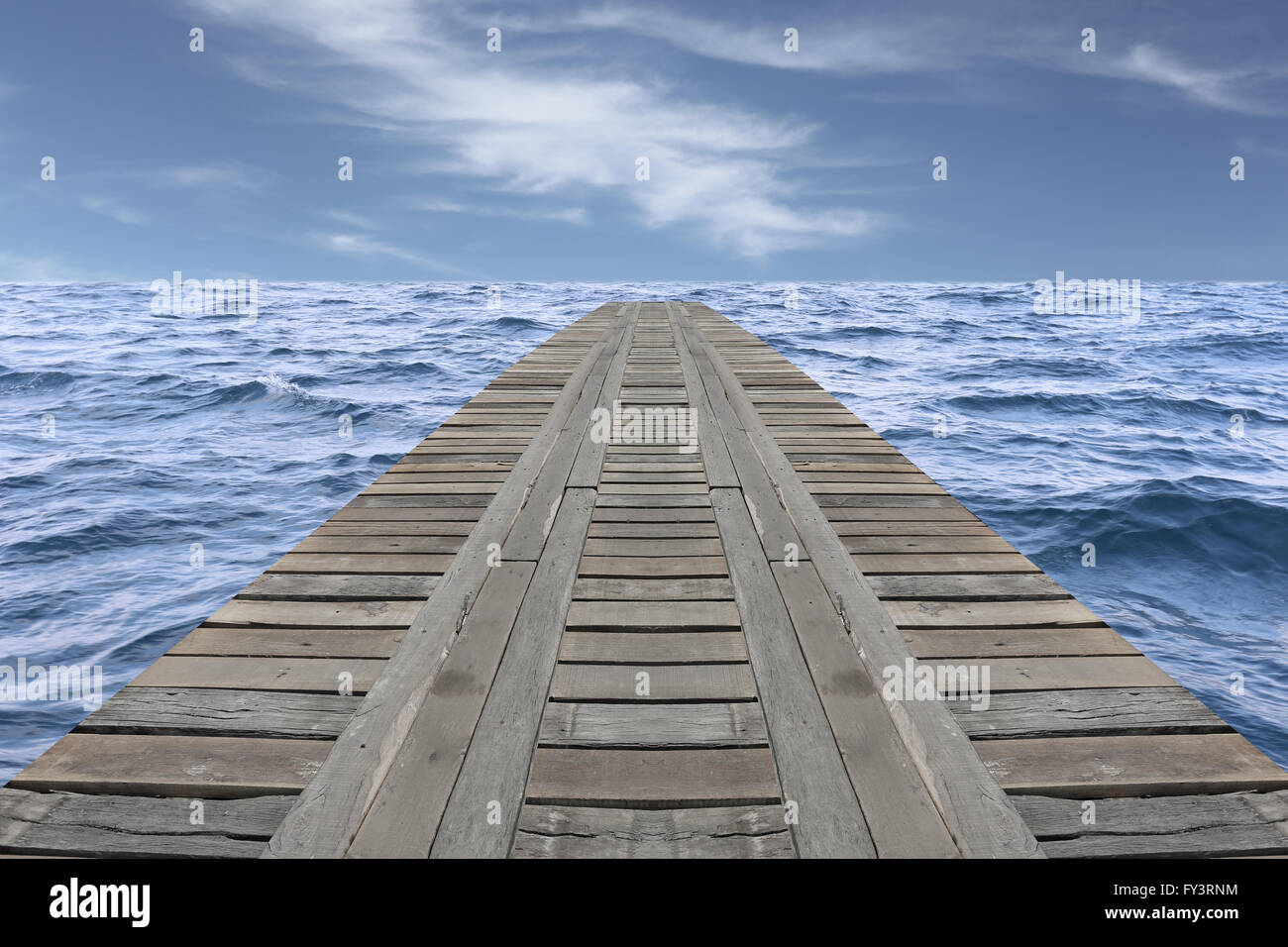 Old wooden bridge in the sea and have slight wave on daytime. Stock Photo