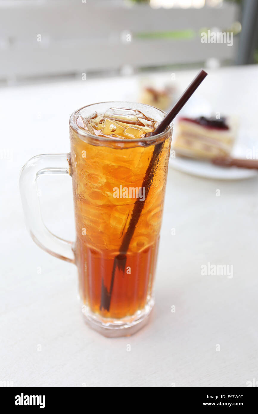 Iced tea and white tube in glass on the coffee shop table. Stock Photo
