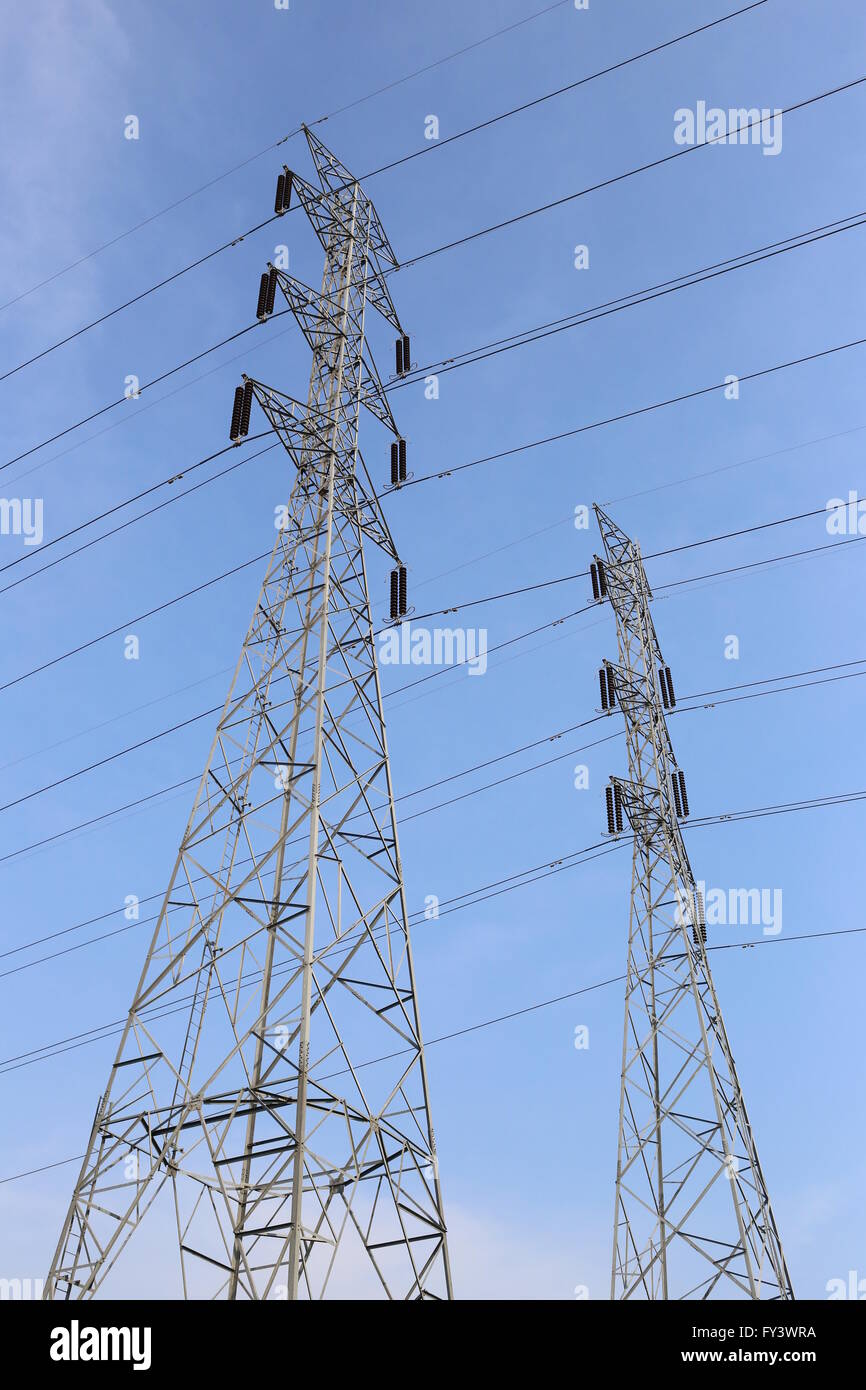 High voltage poles on blue sky in rural areas of the Thailand. Stock Photo