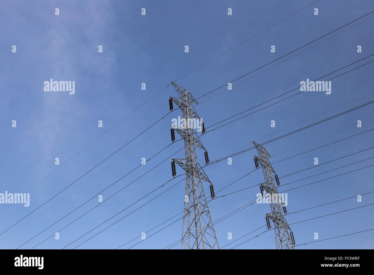 High voltage poles on blue sky in rural areas of the Thailand. Stock Photo