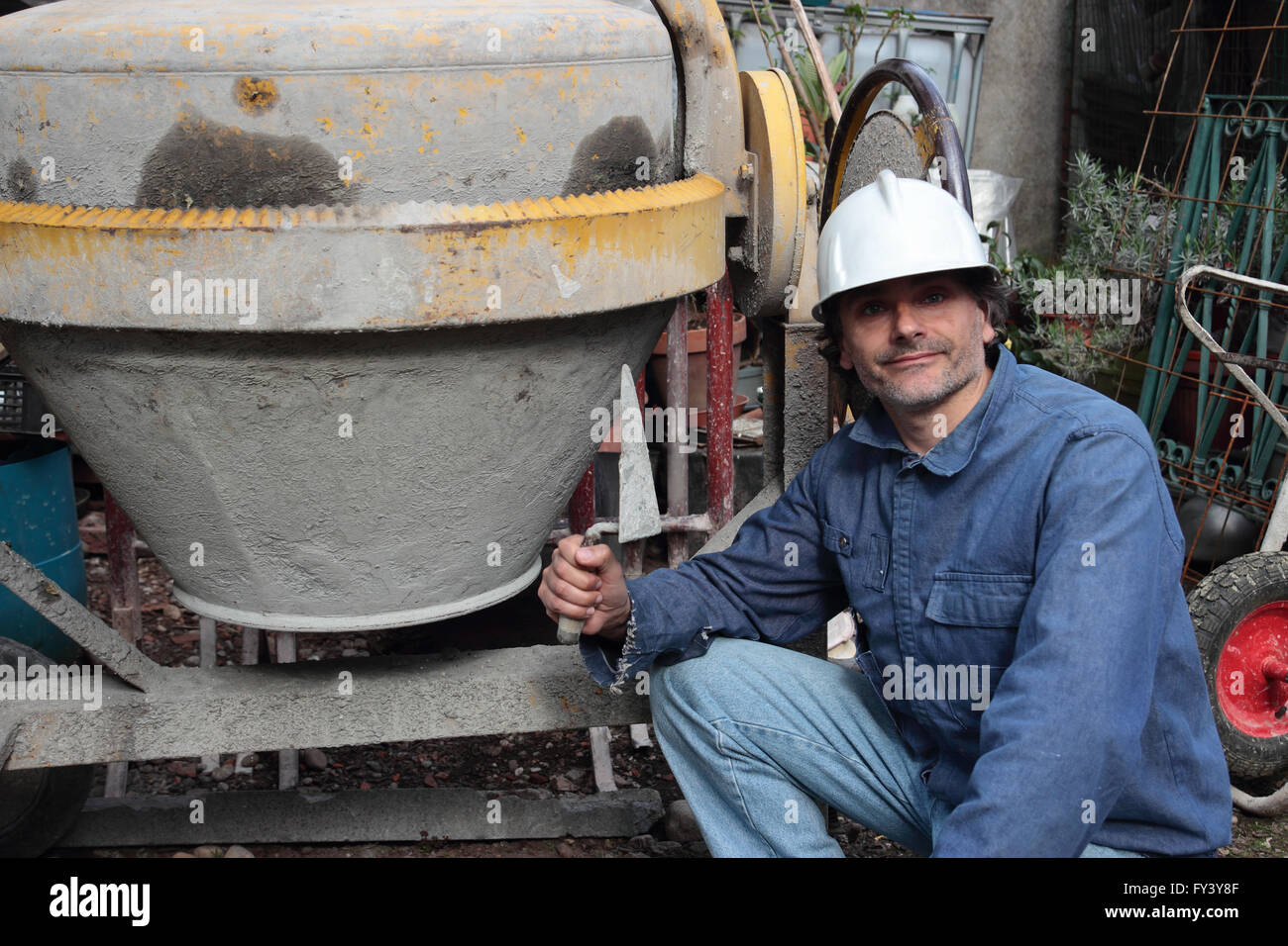 Construction Worker with trowel and cement mixer Stock Photo Alamy