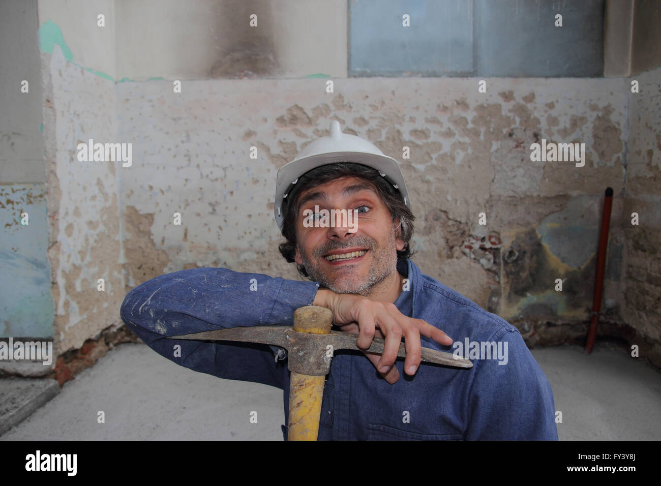 smiling Construction worker holding a pick axe Stock Photo