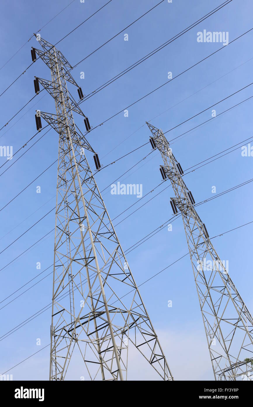 High voltage poles on blue sky in rural areas of the Thailand. Stock Photo
