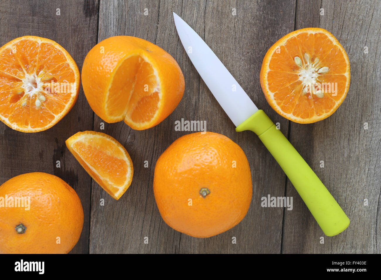 Mandarin oranges and acrylic knife placed on the old wooden floor,design concept for about health foods. Stock Photo