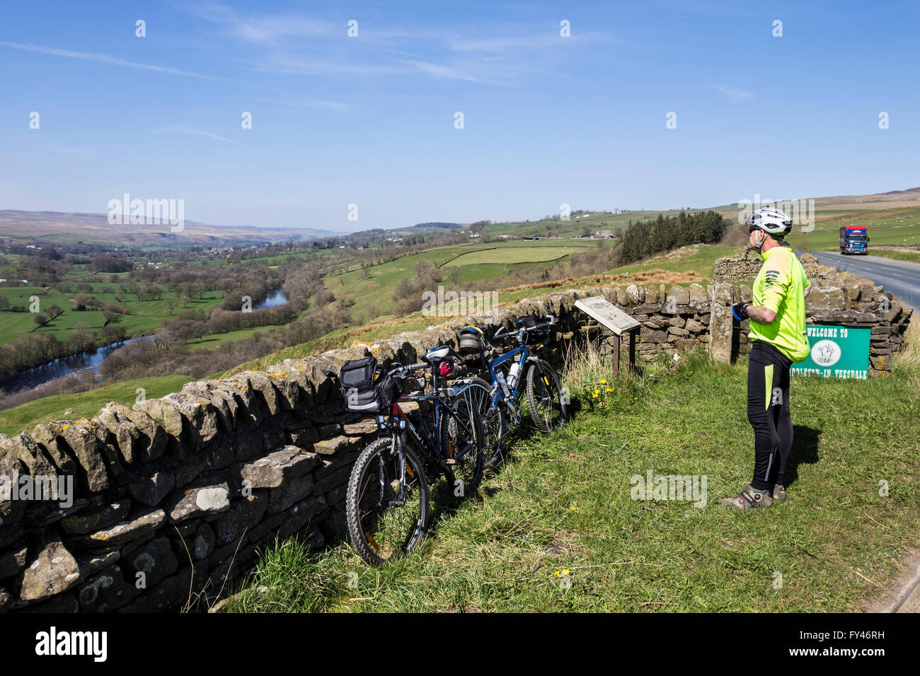 Teesdale, County Durham, UK.  21st April, UK Weather. Cyclist in the North Pennines enjoying the view along the River Tees at Whistle Crag near Middleton-in-Teesdale as the warm spring weather continues. Stock Photo