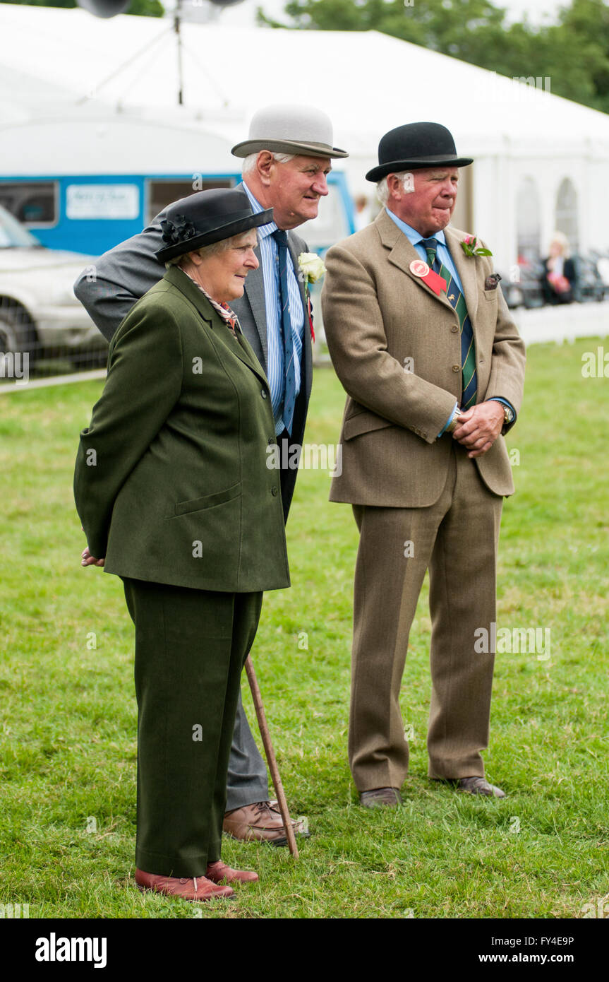 Portrait image of three smartly dressed people wearing hats 'judging' at a country show in England. Stock Photo