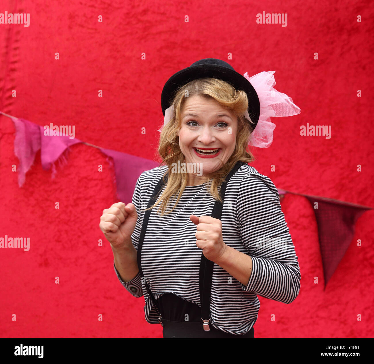 Female clown with bowler hat and pink ribbon smiling with fists clenched Stock Photo Alamy