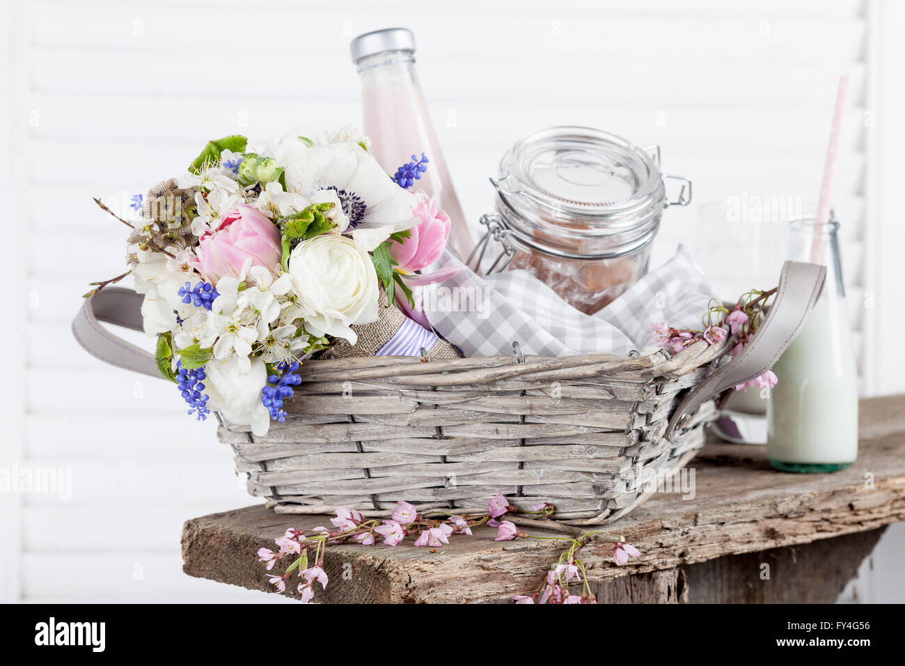 Bouquet from pink tulips lying in picnic basket with milkshake and candies Stock Photo