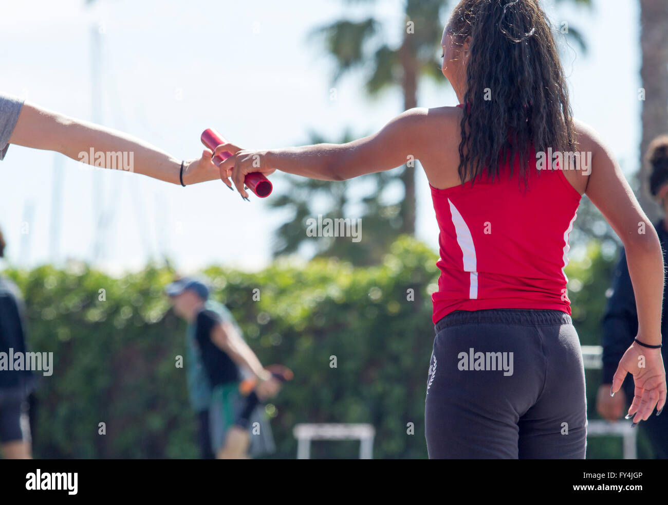 Track athletes practicing relay baton pass Stock Photo