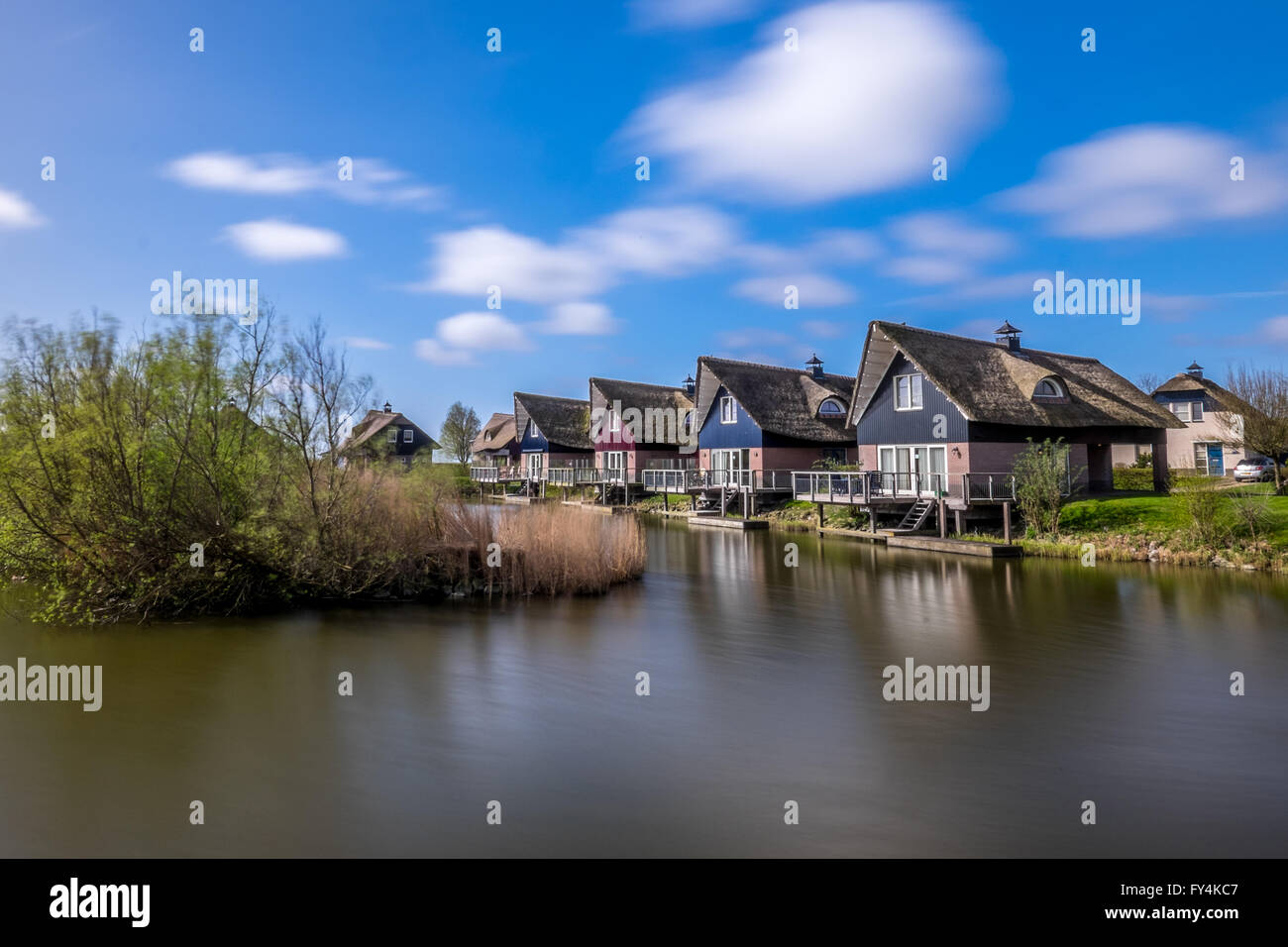 A beautiful bridge arches across a canal in Makkum holiday villiage in Friesland, The Netherlands. Stock Photo