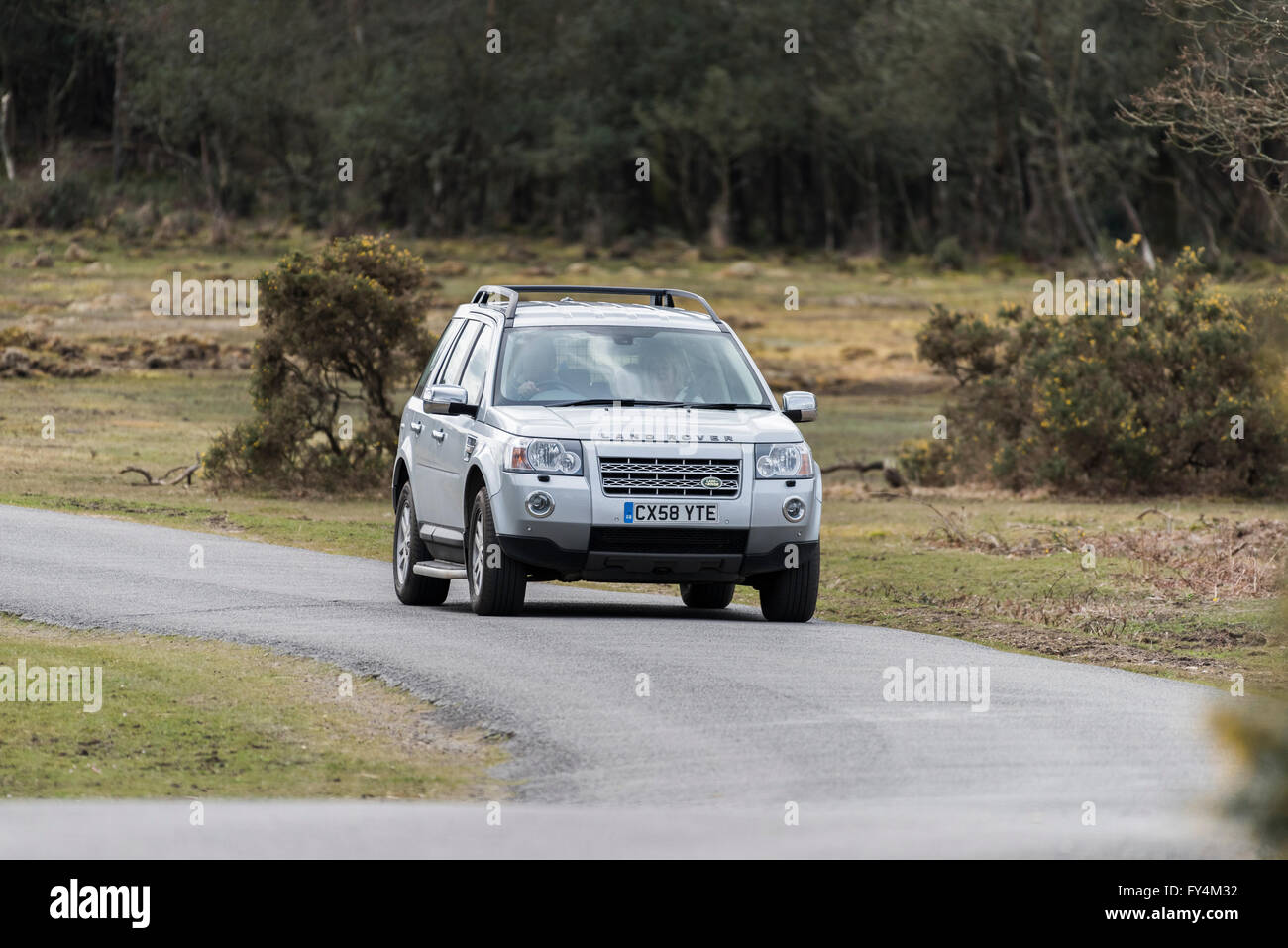 A Land Rover Freelander traveling along a road in the New Forest National Park, Hampshire, England, United Kingdom. Stock Photo
