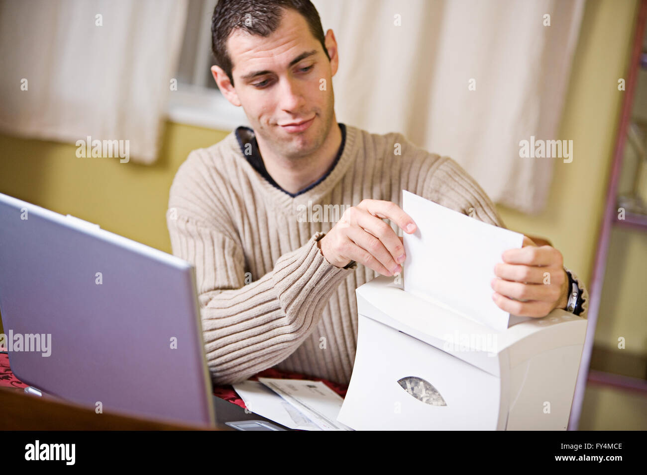 Man and woman indoors working on finances and writing checks. Stock Photo